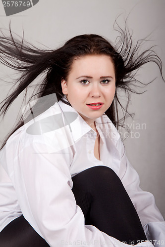 Image of Disheveled long-haired woman in a white men's shirt