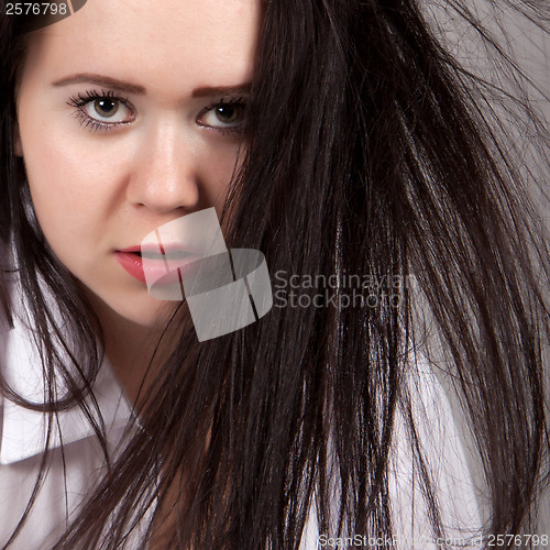 Image of Disheveled long-haired woman in a white men's shirt