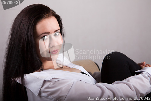 Image of Portrait of long-haired woman in a white men's shirt