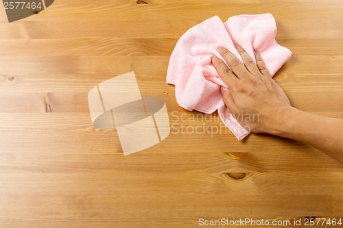 Image of Cleaning table by pink rag