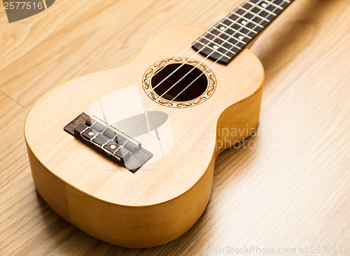 Image of Ukulele over the wooden background