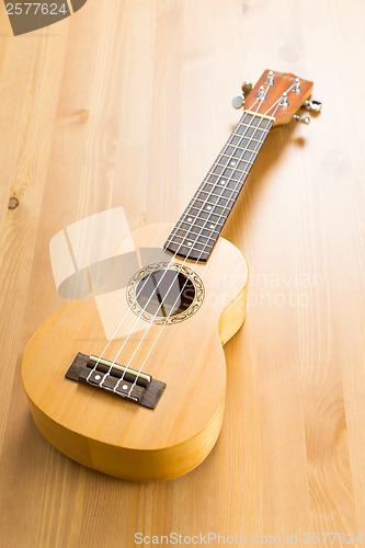 Image of ukulele on wood background