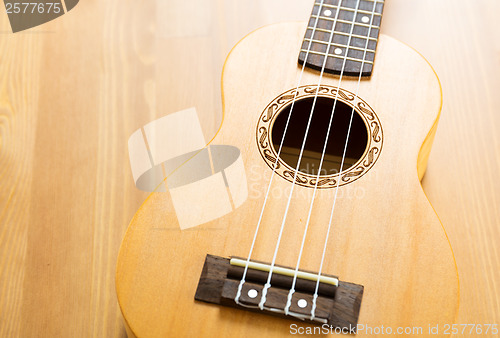 Image of ukulele on wood background