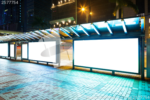 Image of Night bus station with blank billboard