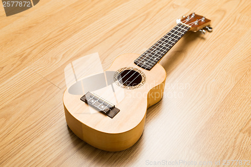 Image of Ukulele over the wooden background