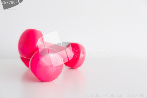 Image of Two pink glossy dumbbell isolated on white 