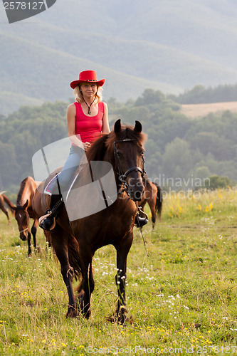 Image of Woman in red hat riding