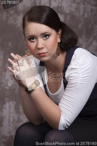 Image of Girl with long hair in a white shirt and a blue vest