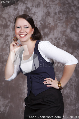 Image of Girl with long hair in a white shirt and a blue vest