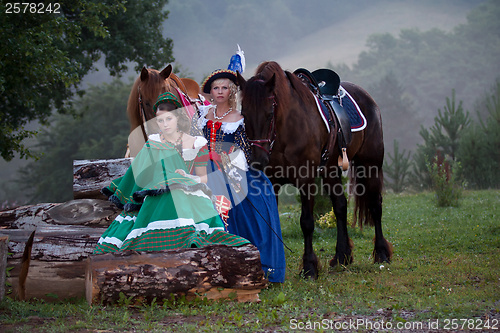 Image of Two women in the royal baroque dress riding