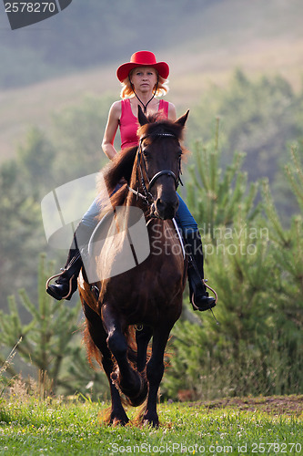 Image of Woman in red hat riding