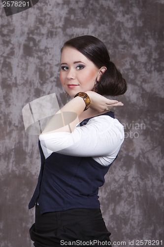 Image of Girl with long hair in a white shirt and a blue vest