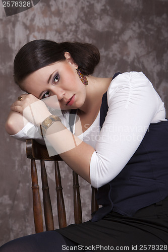 Image of Girl with long hair in a white shirt and a blue vest