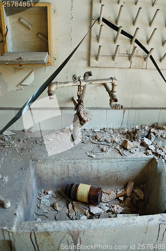 Image of industrial sink with reel tape and bottle of chemical