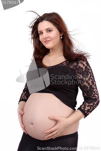 Image of beautiful pregnant woman tenderly holding her tummy isolated on white background