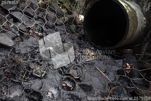 Image of environmental pollution. engine oil from a pipe