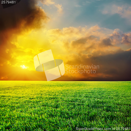 Image of dramatic sunset over green grass field