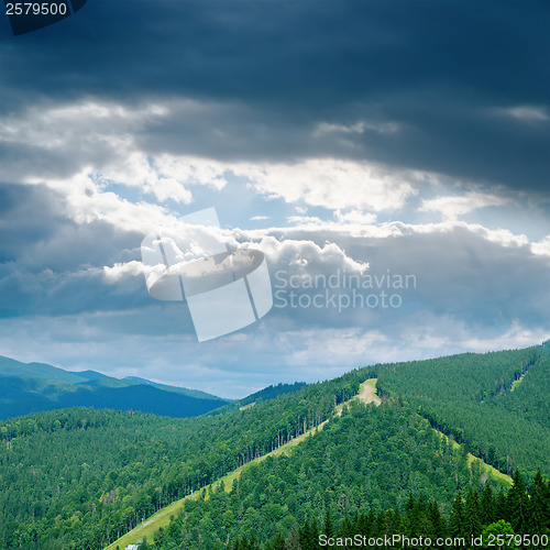 Image of dramatic low clouds over green mountain
