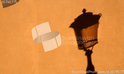 Image of shadow of street lamp on yellow wall