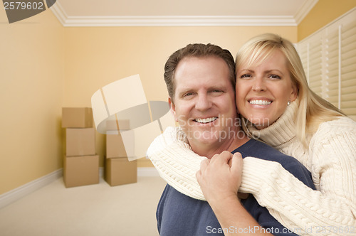Image of Happy Affectionate Couple in Room of New House with Boxes