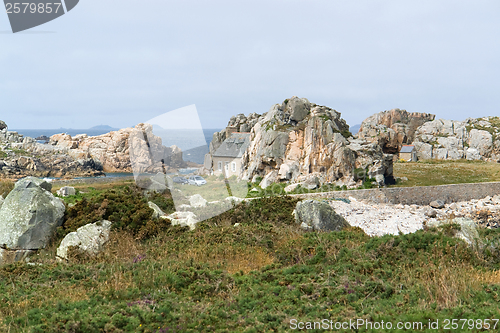 Image of house between rock formation