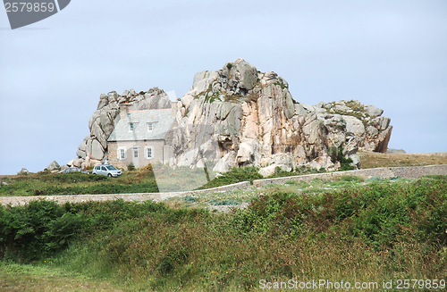 Image of house between rock formation