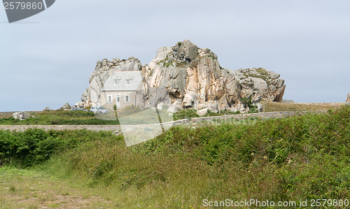 Image of house between rock formation