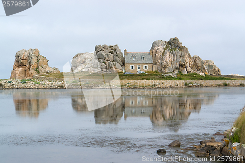 Image of house between rock formation