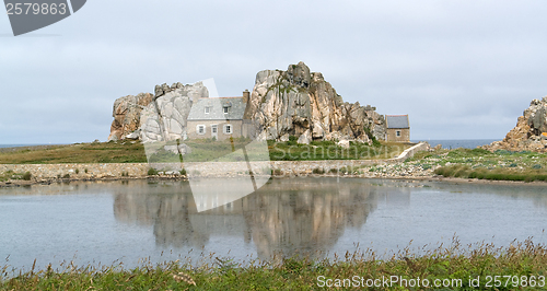 Image of house between rock formation