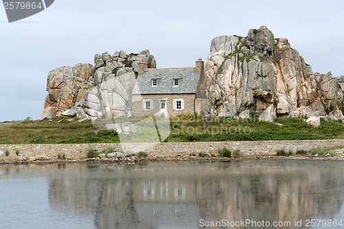 Image of house between rock formation