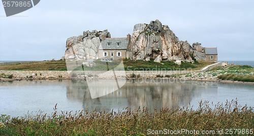 Image of house between rock formation