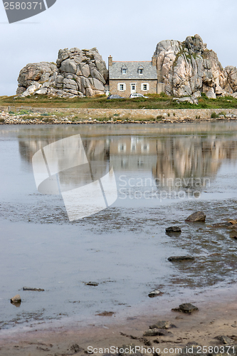 Image of house between rock formation