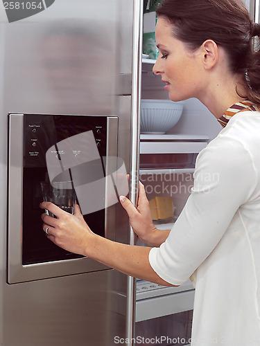 Image of woman in front of the fridge aa