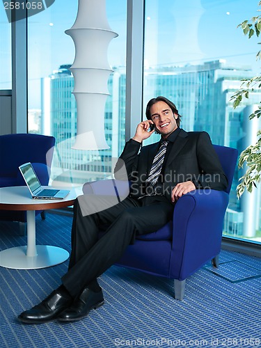 Image of Businessman with laptop in office