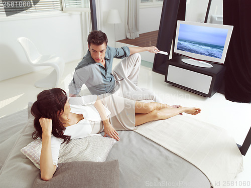 Image of couple sitting on sofa and watching tv