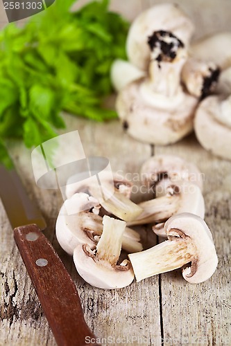 Image of  fresh sliced champignons with parsley and old knife