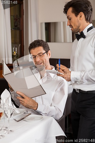 Image of Waiter serving a couple in a restaurant