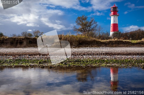 Image of landscape baltic sea dunes lighthouse in red and white 