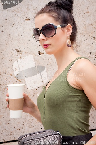 Image of attractive young woman with smartphone and sunglasses outdoor