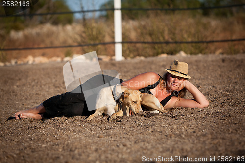 Image of young woman training horse outside in summer