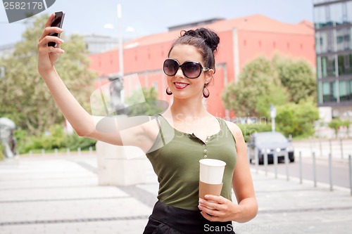 Image of attractive young woman with smartphone and sunglasses outdoor