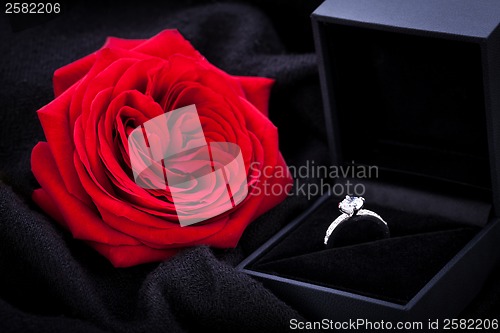 Image of red rose and diamond ring in a box 