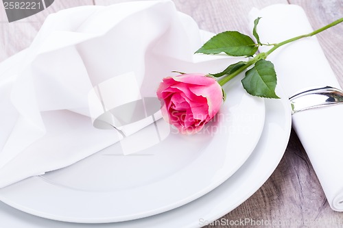 Image of Table setting with a single pink rose