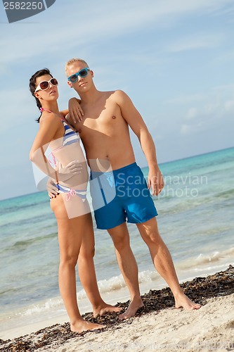 Image of Sexy trendy couple posing in swimwear at the sea