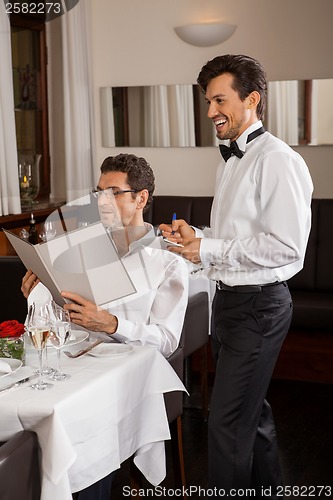 Image of Waiter serving a couple in a restaurant