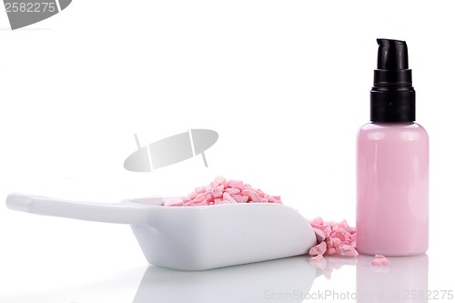 Image of pink body lotion in dispenser and aroma salt isolated