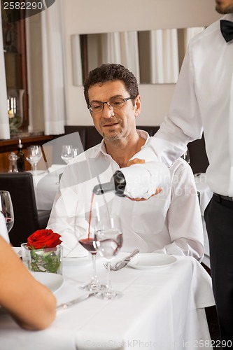 Image of Waiter serving a couple in a restaurant