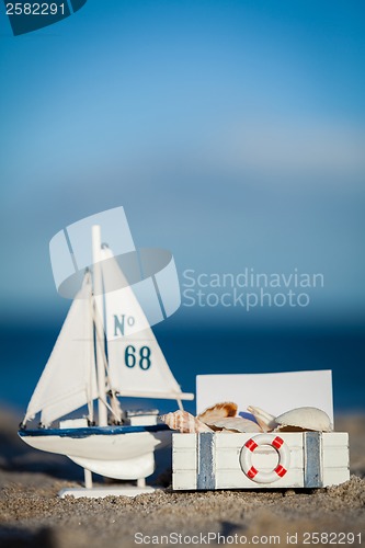 Image of sailing boat and seashell in sand decoration closeup