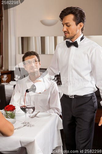 Image of Waiter serving a couple in a restaurant