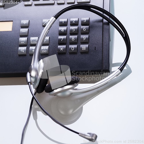 Image of office desk with telephone and headset objects 